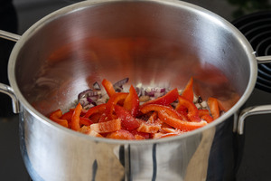 Paprika zu den Zwiebeln im Topf geben
