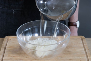 Für die Füllung der vietnamesischen Frühlingsrollen die Glasnudeln mit kochendem Wasser übergießen.