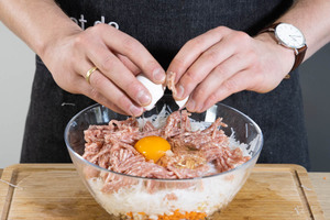 Für die Frühlingsrollen mit Hackfleisch das Hack in die Schüssel geben und ein Ei dazugeben.
