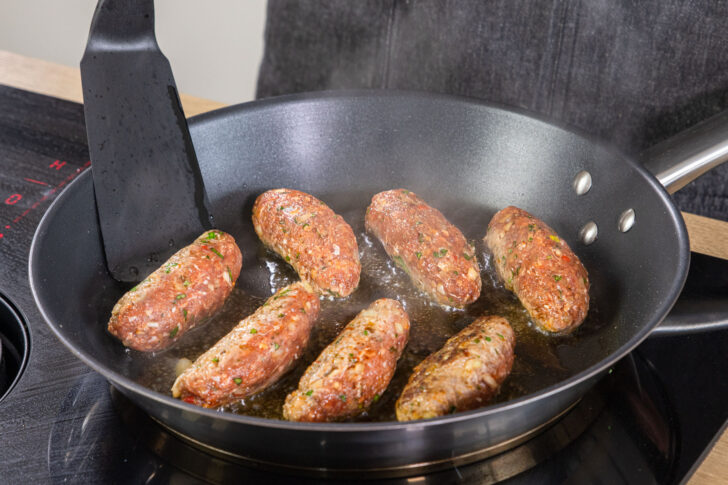 Cevapcici in die Pfanne geben