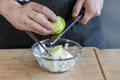 Limettenschale zu Ziegenfrischkäse reiben