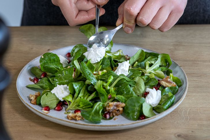 Ziegenkäse auf Feldsalat verteilen