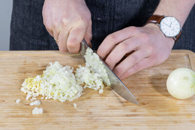 Zwiebeln, Ingwer und Knoblauch in feine Würfel schneiden