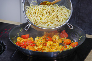 Spaghetti in die Pfanne geben