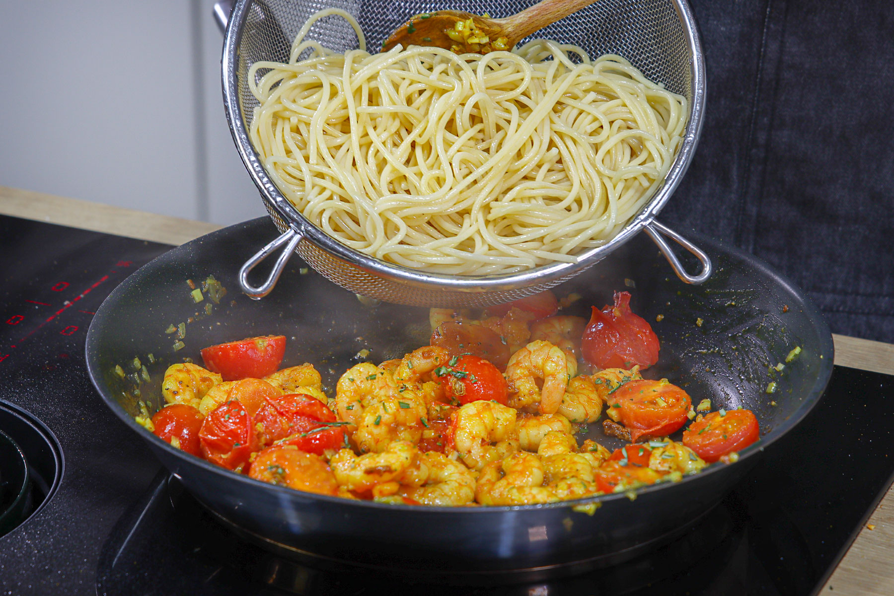 Spaghetti in die Pfanne geben