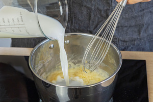 Milch zur Mehlschwitze gießen