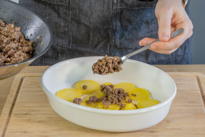 Kartoffeln und Hackfleisch in Auflaufform geben