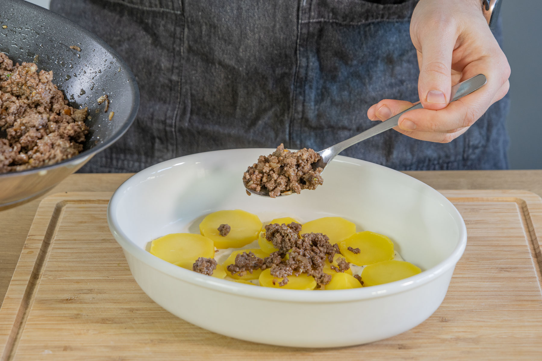 Kartoffeln und Hackfleisch in Auflaufform geben
