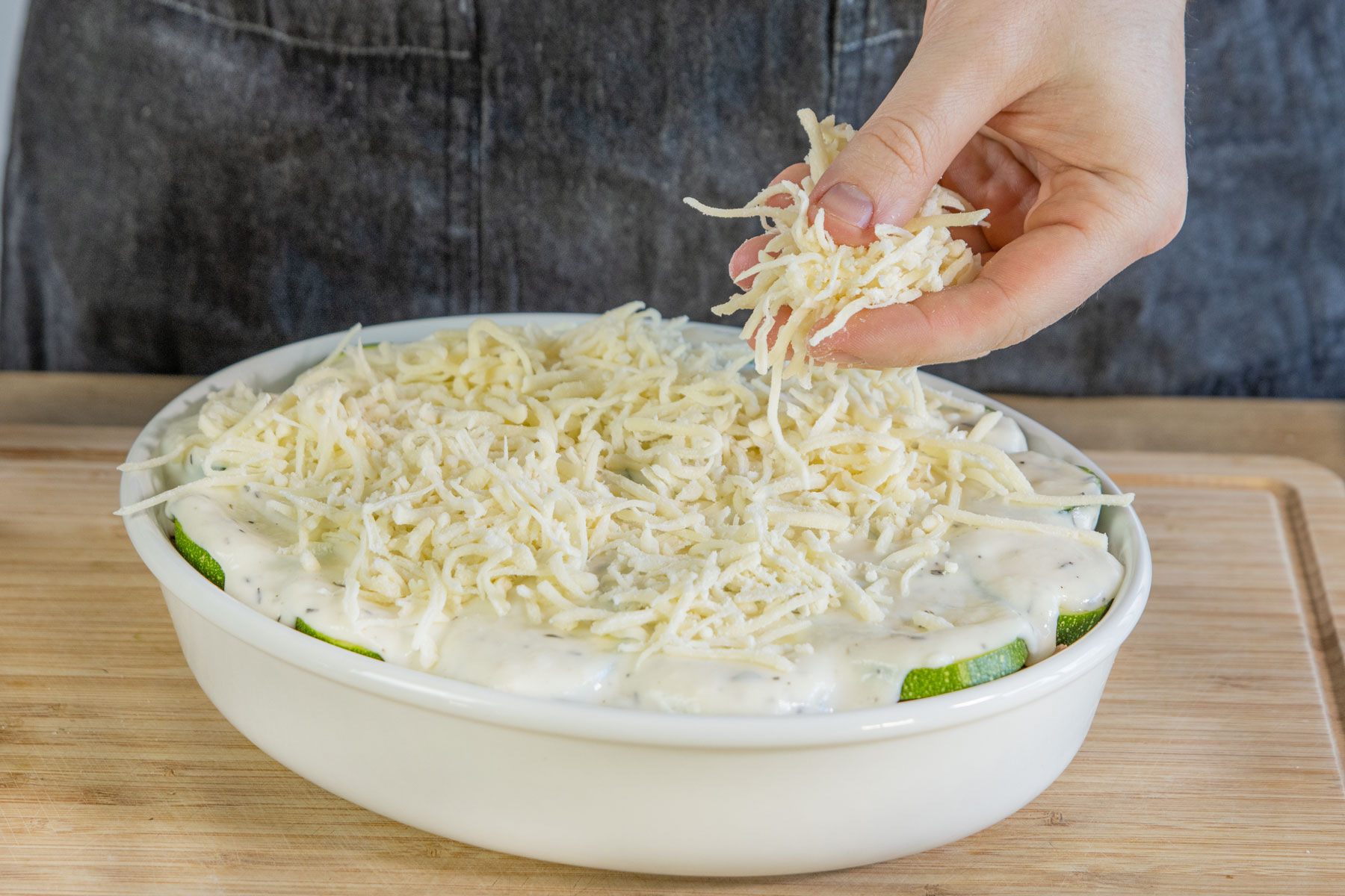 Kartoffel-Zucchini-Auflauf mit Käse bedecken
