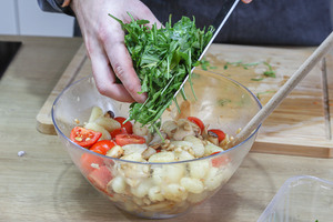 Rucola zum Salat geben