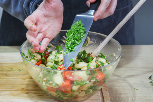 Petersilie zum leichten Gnocchi-Salat geben