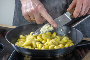 Knoblauch in die Pfanne geben