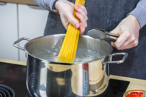 Spaghetti in den Topf geben