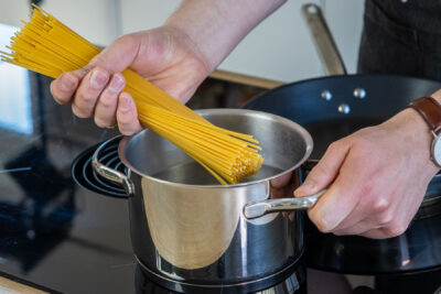 Spaghetti in den Topf geben