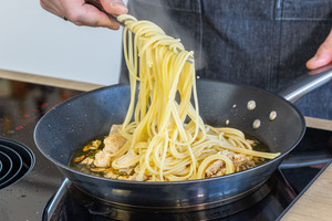 Spaghetti in die Pfanne geben