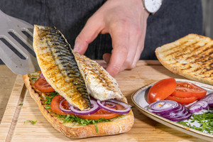 Fisch auf das türkische Fischbrötchen geben