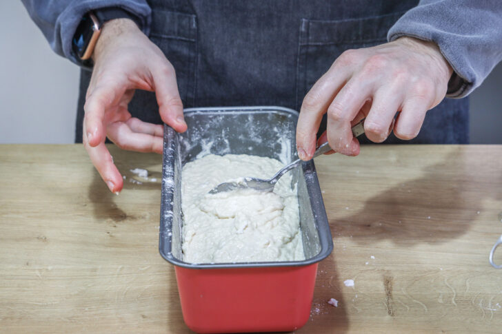 Teig für veganen Kokoskuchen in die Form geben