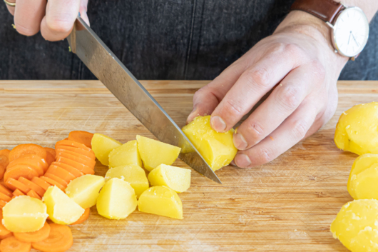 Karotten und Kartoffeln in Würfel schneiden