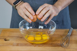 Eier in eine Schüssel schlagen
