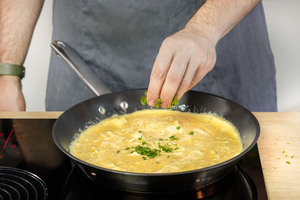 Petersilie auf das Omelette streuen