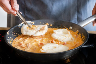 Die Schnitzel in die Pfanne mit der Paprikasauce geben und alles 10 Minuten köcheln lassen.