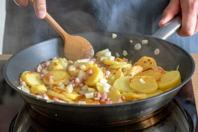 Schinken und Zwiebeln in der Pfanne mit braten