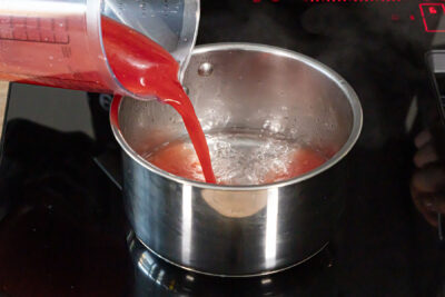 Blutorangensaft zum Zuckerwasser gießen