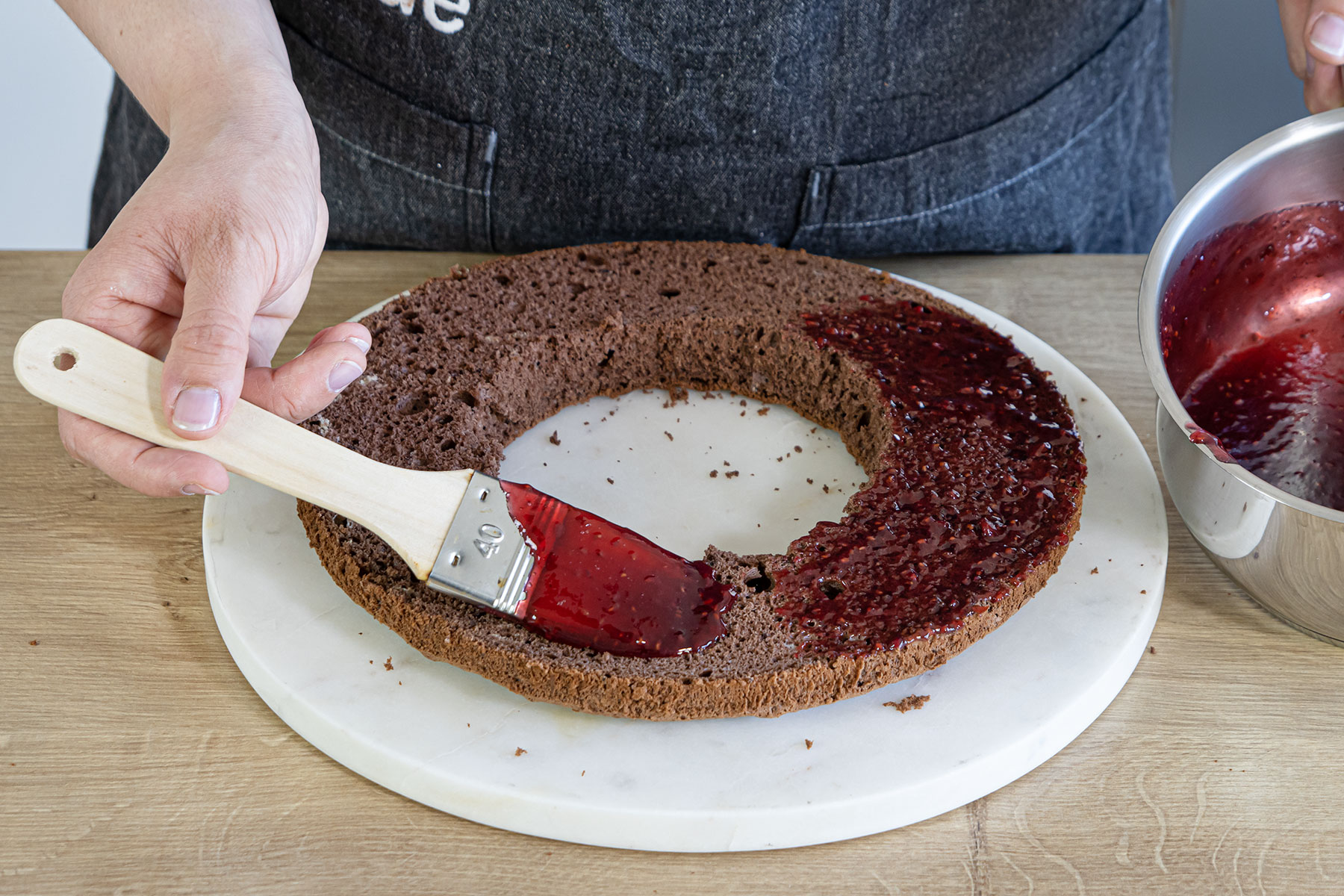 Biskuitboden mit HImbeerkonfitüre einstreichen