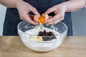 Butter, Rosinen und Ei hinzugeben