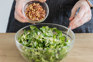 Speck und Pinienkerne dazugeben