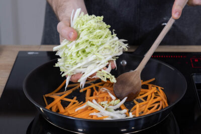 Gemüse für die veganen Frühlingsrollen anschwitzen.