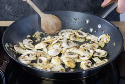 Zwiebeln, Knoblauch und Champignons anbraten