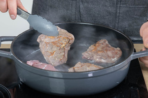 Fleisch aus dem Bräter nehmen