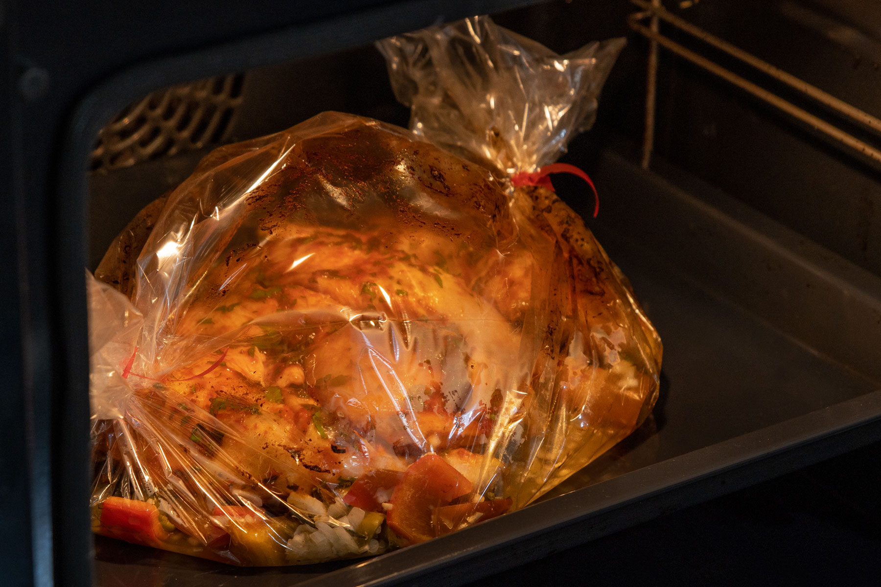 Mediterrane Hähnchenschenkel im Bratschlauch in den Ofen stecken.