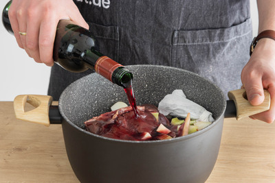 Rotwein zu den Hasenkeulen gießen