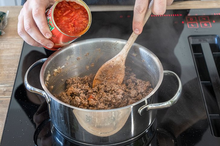 Tomaten zur klassischen Bolognese geben