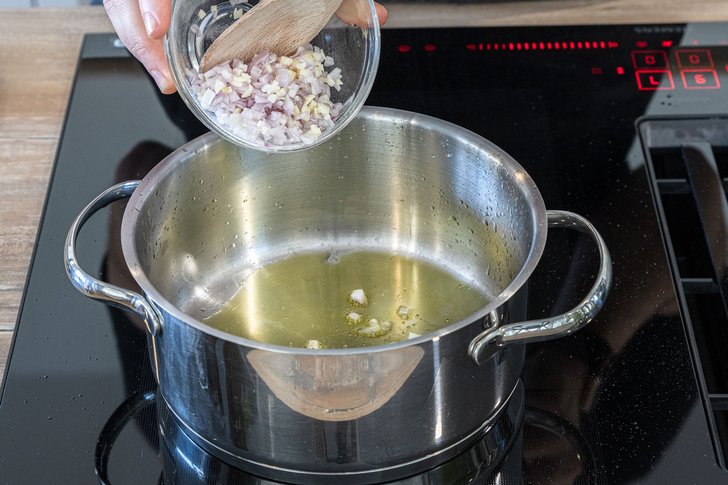 Zwiebel in den Topf geben