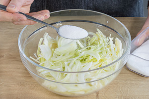 Zucker und Salz zum Weißkraut geben