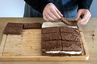 Teigdeckel auf den Milchschnittenkuchen verteilen