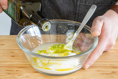Olivenöl zum Dressing geben