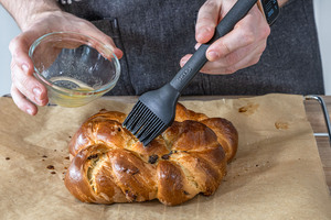 Luftiges Osterbrot mit Hefeteig mit Butter bestreichen