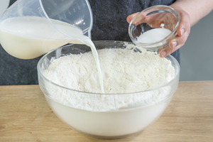 Milch und Zucker zum Mehl geben