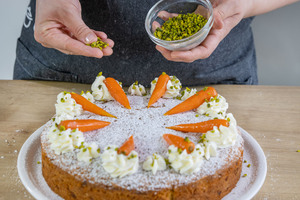 Rüblikuchen mit Pistazien bestreuen