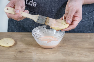 Osterplätzchen mit Zuckerguss bestreichen