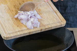 Schalotte für das Paprika-Sahne-Hähnchen anbraten.