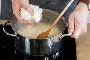 Parmesan in die Risotto-Masse geben.