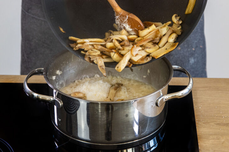 Die gebratenen Pilze in die Masse für das einfache Pilzrisotto geben.