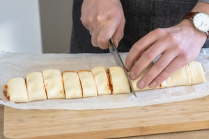 gerollten Pizzateig in Schnecken schneiden