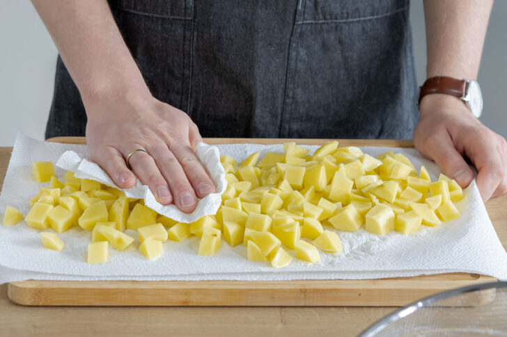 Kartoffelstückchen auf Küchenkrepp abtropfen lassen 