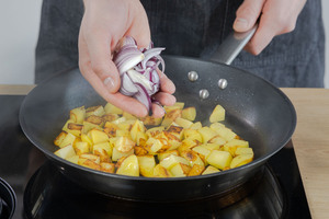Zwiebel zu gerösteten Kartoffeln geben